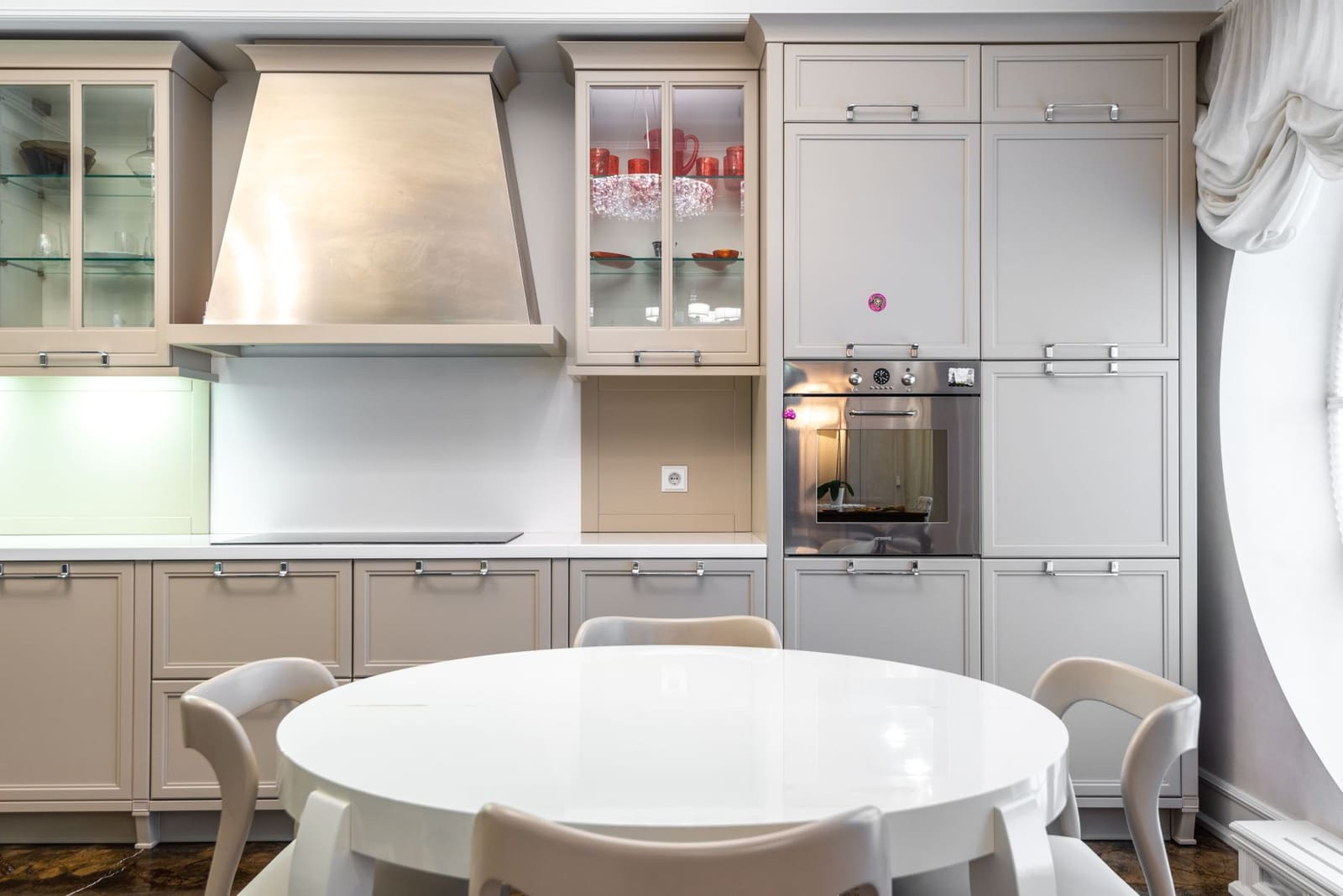 A light kitchen with cream cabinetry and a round dining table